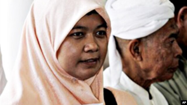 A Thai-Muslim woman activist holds a book with the cover showing a photo of missing Thai lawyer Somchai Neelapaichit (file photo)