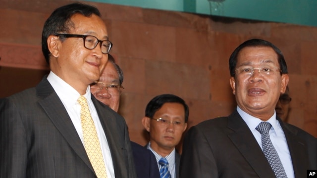 Cambodian Prime Minister Hun Sen, right, talks with the main Opposition Party leader Sam Rainsy, left, of Cambodia National Rescue Party, after their meeting in Senate headquarters in Phnom Penh, Cambodia, July 22, 2012. 