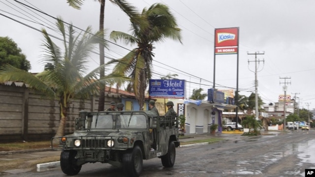 A navy vehicle drives along a street in the coastal town of Barra de Navidad as the community prepares for the arrival of Hurricane Bud along the Pacific coast of Mexico, May 25, 2012. 
