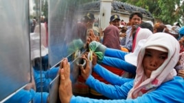 Garment workers push against the gates of a factory owned by Sabrina Garment Manufacturing during their protest in Kampong Speu province, west of the capital Phnom Penh, Cambodia, June 3, 2013.