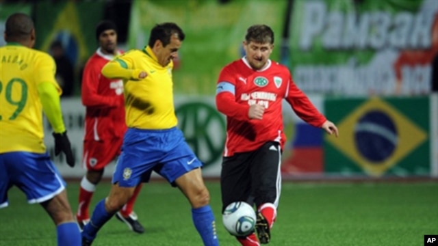 Chechnya leader Ramzan Kadyrov (r) fights for the ball with Brazil's 2002 World Cup-winning side player Dunga (c) during an exhibition match between Brazil's 2002 World Cup-winning side and 'team Kadyrov' in Grozny on March 8, 2011