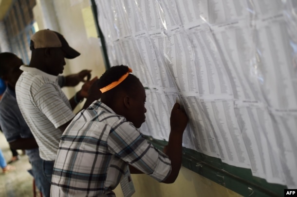 People look the voting lists at polling station at the Lycee National in the Petion Ville suburb of Port-au-Prince, Haiti, during the presidential and legislative elections, Nov. 20, 2016.