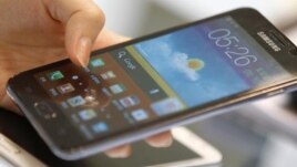 A customer tries the Samsung Galaxy Note smartphone at a store in Seoul August 26, 2012. Apple Inc's decisive triumph over Samsung Electronics in the most closely watched patent trial in years could open the door for Microsoft Corp to finally hop on board