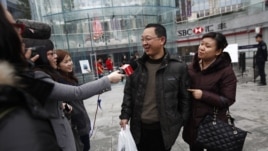 Los medios de comunicación entrevistan a un feliz comprador de un iPhone 5 en China.