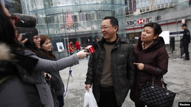 Los medios de comunicación entrevistan a un feliz comprador de un iPhone 5 en China.