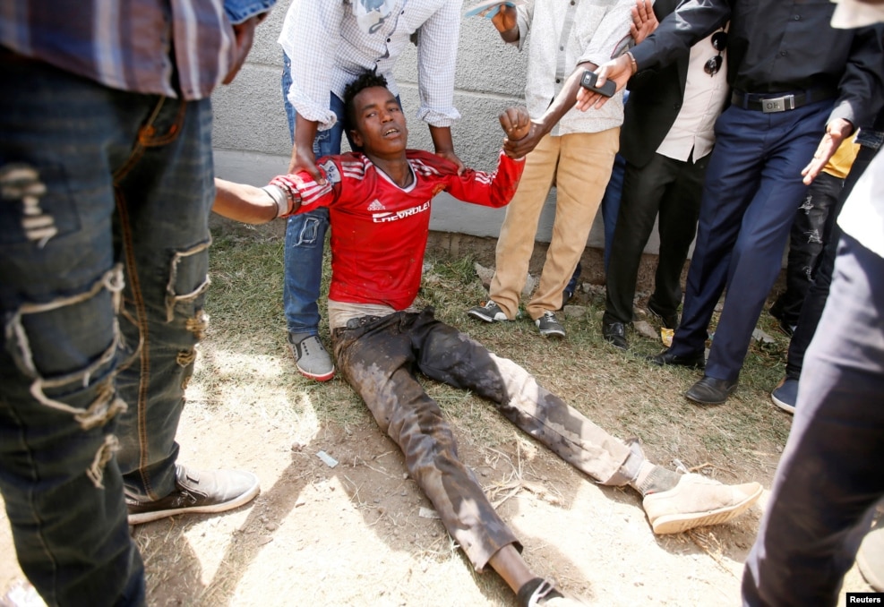FILE -- People assist an injured protester during Irrechaa, the thanksgiving festival of the Oromo people in Bishoftu town of Oromia region, Ethiopia.
