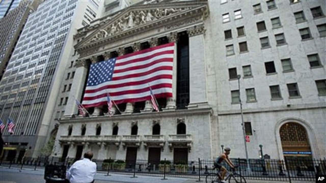 A cyclist rides past the New York Stock Exchange in New York, Aug. 5, 2011
