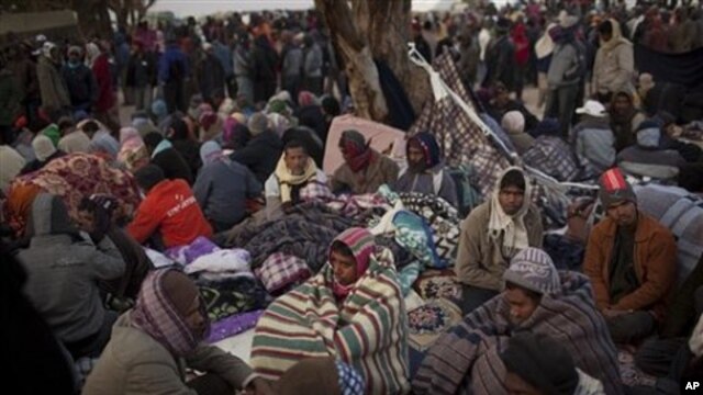 Men, who worked in Libya and fled the unrest in the country, wait for buses to be repatriated in a refugee camp at the Tunisia-Libyan border, in Ras Ajdir, Tunisia, March 10, 2011