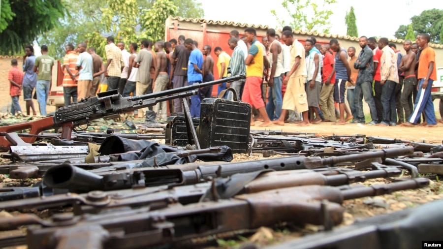 Suspected fighters are paraded before the media by Burundian police near a recovered cache of weapons after clashes in the capital Bujumbura, Burundi, Dec. 12, 2015.