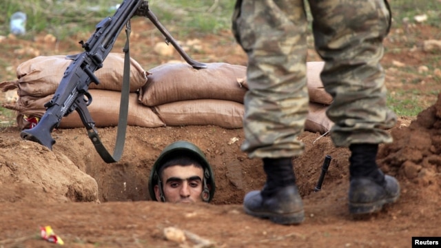 A Turkish soldier takes up position near the Syrian border in the Turkish  town of Ceylanpinar, Sanliurfa province, November 30, 2012.