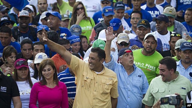 Opposition presidential candidate and Zulia's state governor Pablo Perez (C) waves to supporters during a rally in Caracas February 9, 2012.
