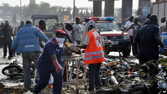 Rescue workers work to recover victims at the site of a blast near Abuja, Nigeria, April 14, 2014.