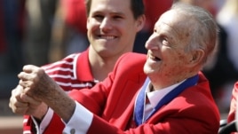 Baseball Hall of Famer Stan Musial pretends to swing a bat before the start of the opening day baseball game between the San Diego Padres and Cardinals, in St. Louis, Missouri, March 31, 2011.