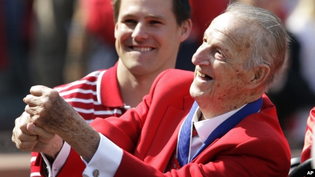 Baseball Hall of Famer Stan Musial pretends to swing a bat before the start of the opening day baseball game between the San Diego Padres and Cardinals, in St. Louis, Missouri, March 31, 2011.