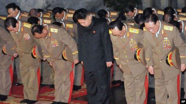 In this Saturday, Dec. 24, 2011 photo released by the Korean Central News Agency and distributed in Tokyo, Sunday, Dec. 25, 2011, by the Korea News Service, Kim Jong Un, center, North Korean leader Kim Jong Il's youngest known son and successor, visits at
