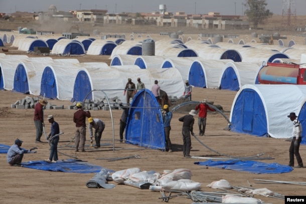 FILE - Workers prepare a tent camp in Khazer west of the Kurdish regional capital Erbil, Iraq, Oct. 11, 2016, for people expected to flee Mosul.