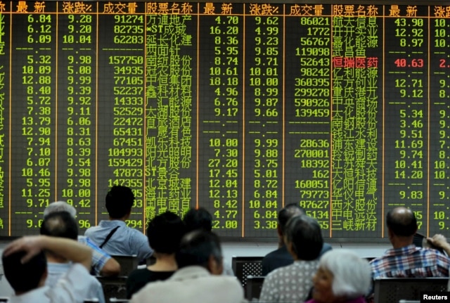 Investors look at stock information on an electronic board at a brokerage house in Hangzhou, Zhejiang province, Aug. 25, 2015.