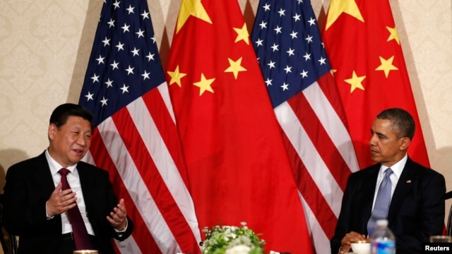 FILE - China's President Xi Jinping speaks during his meeting with U.S. President Barack Obama (R), on the sidelines of a nuclear security summit, in The Hague, March 24 2014. 