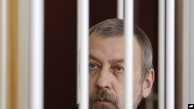 Former presidential candidate Andrei Sannikov sits in a cage during a court hearing in Minsk, April 27, 2011
