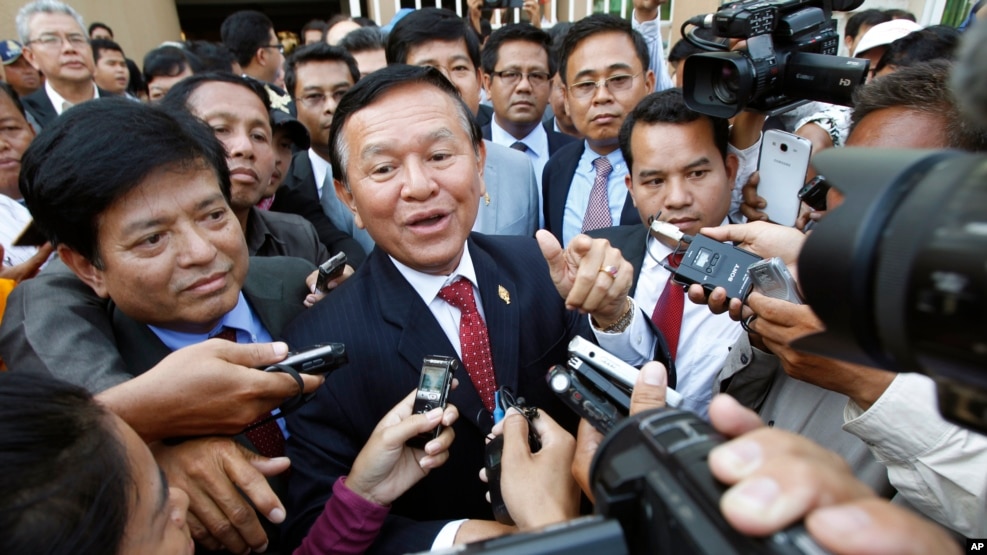 Cambodia's main opposition Cambodia National Rescue Party Deputy President and National Assembly Deputy President Kem Sokha, center, speaks to reporters outside the Phnom Penh Municipality Court in Phnom Penh, Cambodia, Wednesday, April 8, 2015. 