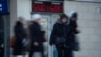 People walk past electronic display board with figures indicating US dollar to Russian ruble currency exchange rate, St. Petersburg, Russia, Dec. 29, 2014.