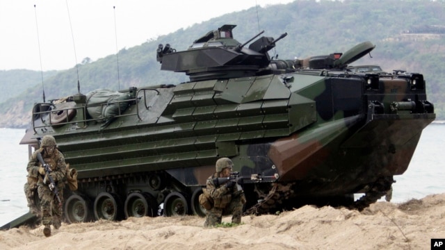 U.S. Marines jump off an amphibious assault vehicle after hitting the ground at a joint military exercise on Hat Yao beach in Chonburi province eastern, Thailand, February 10, 2012.