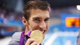 Michael Phelps of the U.S. poses with his gold medal after winning the men's 4x100m medley relay final during the London 2012 Olympic Games at the Aquatics Centre August 4, 2012.