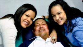 Venezuela's President Hugo Chavez smiles in between his daughters, Rosa Virginia (R) and Maria while recovering from cancer surgery in Havana in this photograph released by the Ministry of Information on Feb. 15, 2013.