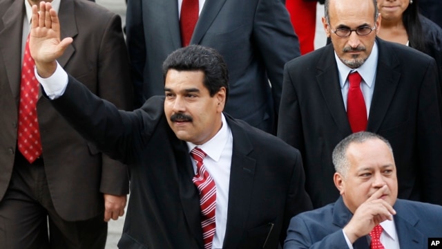 Venezuela's Vice President Nicolas Maduro, left, and Diosdado Cabello, president of Venezuela's National Assembly, gesture to supporters as they arrive at the National Assembly for the state-of-the-nation address in Caracas, Feb. 28, 2013. 