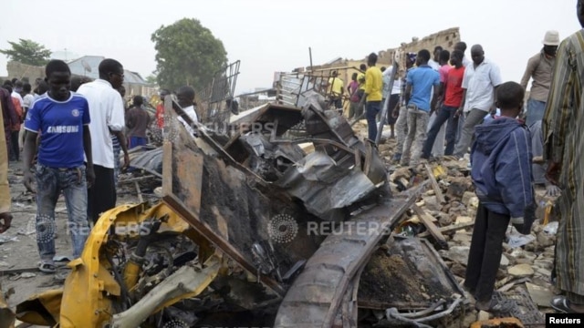 People look at damage in a market area after a bomb explosion in Ajilari-Gomari near the city's airport, Maiduguri, Borno State March 2, 2014.