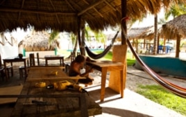 A Surf for Life volunteer crafts a desk out of local guanacaste wood in El Cuco, El Salvador.