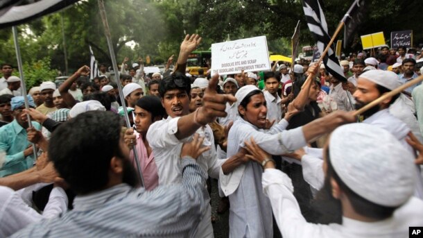 FILE - Indian Muslim men shout slogans during a protest against tensions in India's northeastern state of Assam, in New Delhi, India, Aug. 8, 2012.