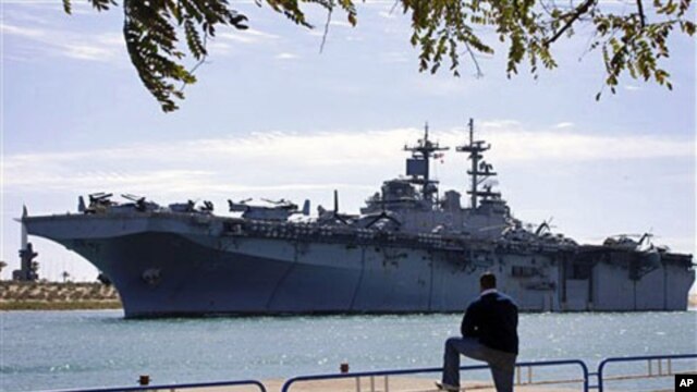 An Egyptian watches US amphibious assault ships USS Kearsarge as it sails at the Suez canal in Ismailia , Mar 2 2011