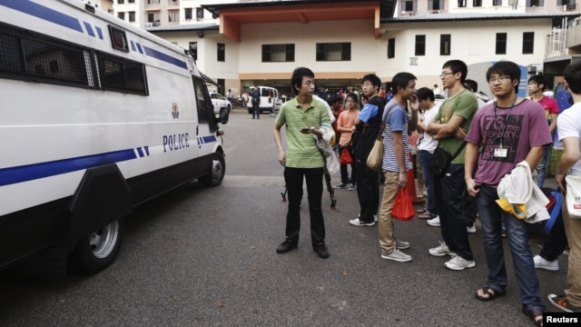 A police van leaves the premises of a dormitory as negotiations with striking bus drivers continue within the building in Singapore, November 26, 2012. 