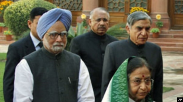 India's Prime Minister Manmohan Singh (in blue turban) and President Pratibha Patil arrive at the parliament on the first day of the budget session in New Delhi. The government will battle both inflation and corruption, February 21, 2011