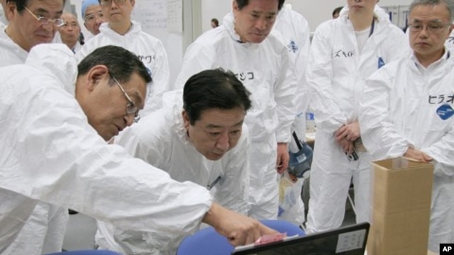 Japan's Prime Minister Yoshihiko Noda (C) listens to Masao Yoshida, director of the Fukushima Daiichi nuclear power plant, while visiting the crippled plant in Fukushima prefecture, September 8, 2011.