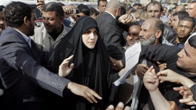 Maha al-Dori, a lawmaker loyal to anti-American Shiite cleric Muqtada al-Sadr, collects the demands of protesters during a protest at Tahrir Square in Baghdad, Iraq, February 23, 2011