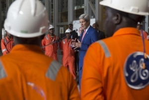 FILE - US Secretary of State John Kerry speaks as he poses with employees of the General Electric (GE) Sonils compound at the Port of Luanda in Luanda, Angola.