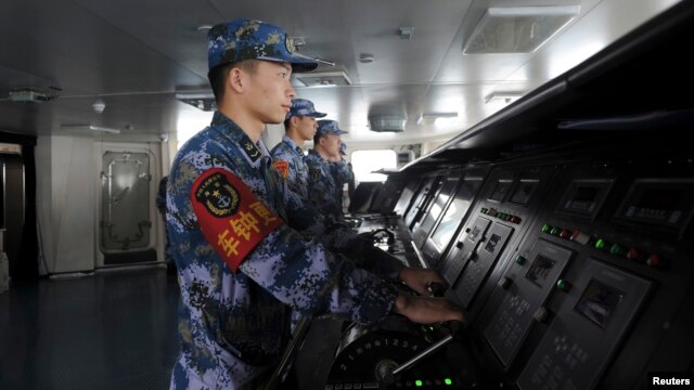 FILE - Chinese naval soldiers are pictured manning their stations on China's first aircraft carrier Liaoning, as it travels towards a military base in Sanya, Hainan province, in this undated picture made available on Nov. 30, 2013. 