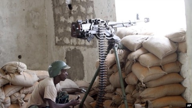 A soldier in the African Union Mission in Somalia (AMISOM) takes his position during fighting between Islamists and government forces in southern Mogadishu, February 14, 2012.