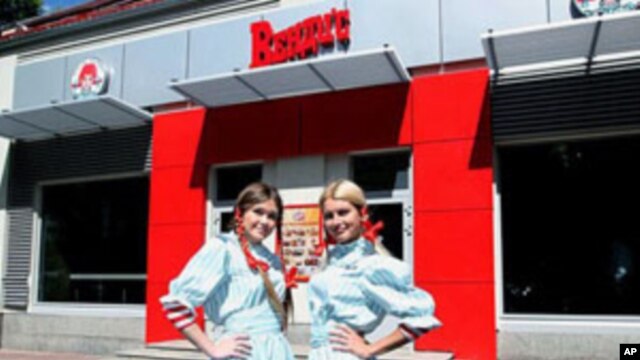 Wendy's Russia workers pose out side of the new restaurant in Moscow, August 2011
