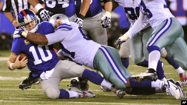 El mariscal de campo de los Gigantes, Eli Manning (10) es atrapado por la defensiva de los Vaqueros de Dallas, en el triunfo de estos últimos por 24 a 17, en East Rutherford, Nueva Jersey.