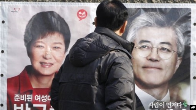 Một người dân dừng lại xem hình 2 ứng cử viên tổng thống Nam Triều Tiên Park Geun-hye (trái), và Moon Jae-in