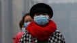 FILE - Women wearing masks make their way amid the heavy haze in Beijing, Feb. 23, 2014.