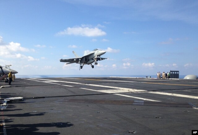 An FA-18 jet fighter takes off on the USS John C. Stennis aircraft carrier in the South China Sea on April 15, 2016.