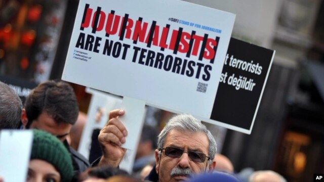 FILE - Turkish journalists are seen gathered to protest the jailing of opposition Cumhuriyet newspaper's editor-in-chief Can Dundar and Ankara representative Erdem Gul, in Istanbul, Dec. 26, 2015.