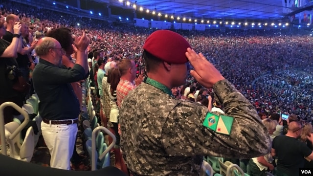 A military policeman salutes as Brazil's national anthem is performed at the start of the opening ceremonies of the 2016 Rio Olympic Games, Aug. 5, 2016, in Rio de Janeiro, Brazil. (P. Brewer/VOA)