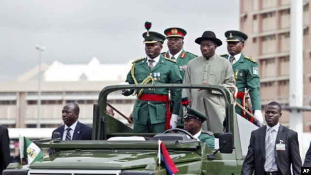 Nigerian president Goodluck Jonathan (right) stands with military aides in a parade convoy during Army Day celebrations in the capital Abuja, 6 Jul 2010 (File Photo)