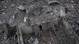 A Palestinian man walks among debris after an Israeli airstrike at Hamas Prime Minister Ismail Haniyeh's office in Gaza City, Saturday, Nov. 17, 2012. 