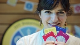 Joanna Choukeir shows some of the cards from a DIY Happiness card game, at the launch of  'Action For Happiness' encouraging meditation, hugging and kindness, in London, April 12, 2011.